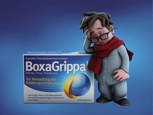 BoxaGrippal-Character mit rotem Schal und Packung